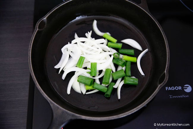 stir frying onions and green onions in a skillet