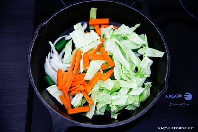 stir frying cabbages and carrots with onions and green onions