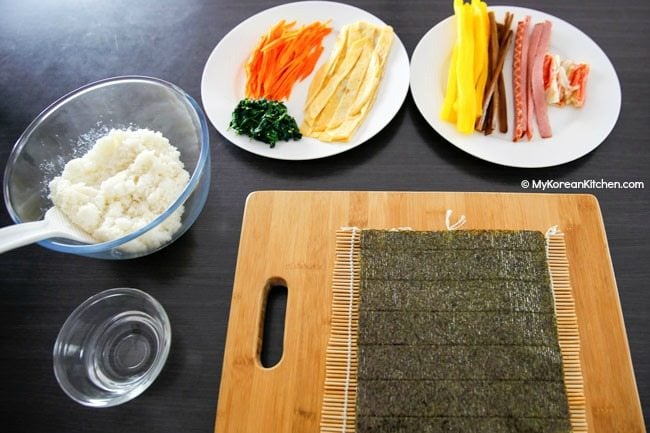 Kimbap ingredients - dried seaweed, seasoned rice, cooked carrots, spinach, egg omelette, yellow radish pickles etc.