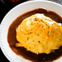 Omurice on a white plate with brown sauce