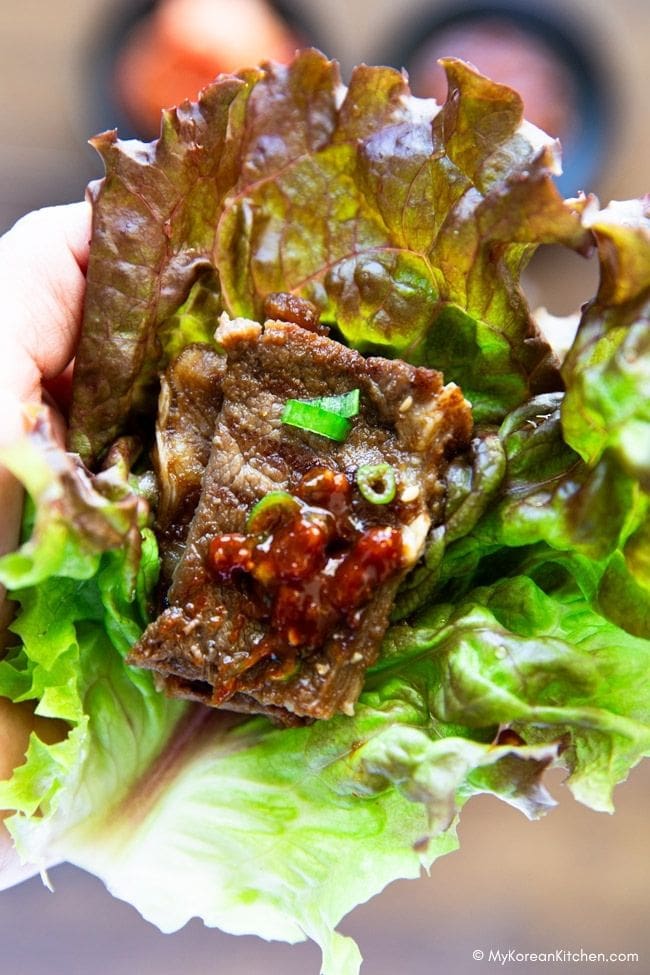 Holding grilled LA galbi in lettuce wrap, ready to eat