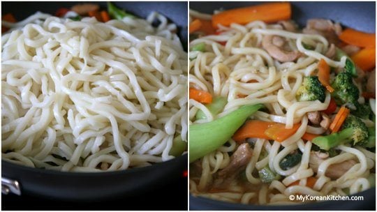 Mixing in udon noodles with chicken and veggies covered in Korean style sauce