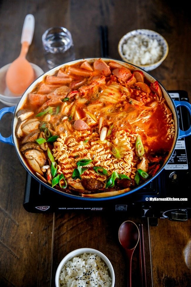 Korean army stew (Budae Jjigae) is a Korean fusion hot pot dish loaded with Kimchi, spam, sausages, mushrooms, instant ramen noodles and cheese. The soup is so comforting and addictive! | Food24h.com