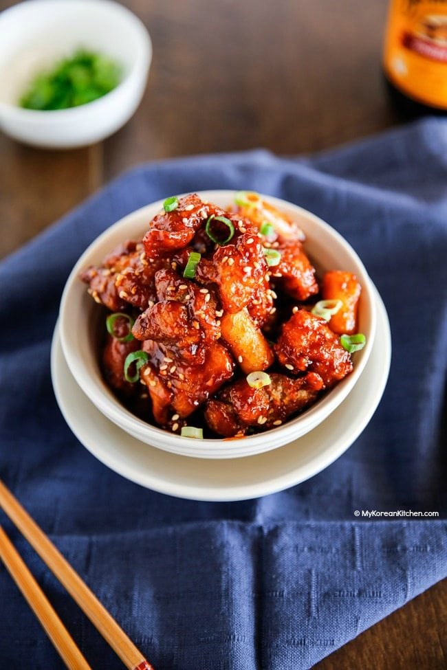 Korean style popcorn chicken garnished with sesame seeds and green onions