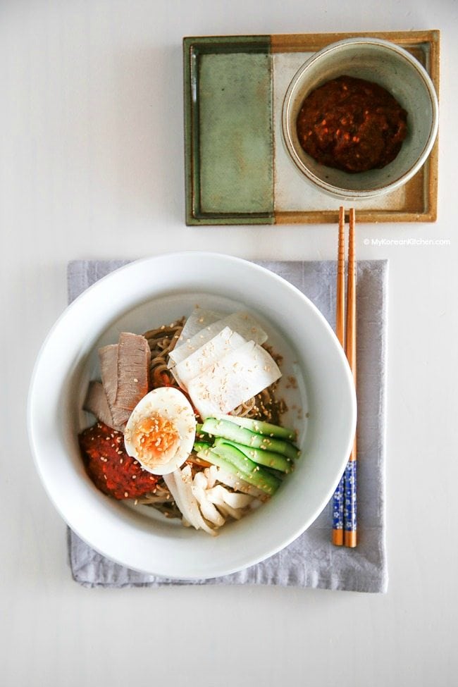 Bibim Naengmyeon (Korean Spicy Cold Noodles) served in a white bowl.