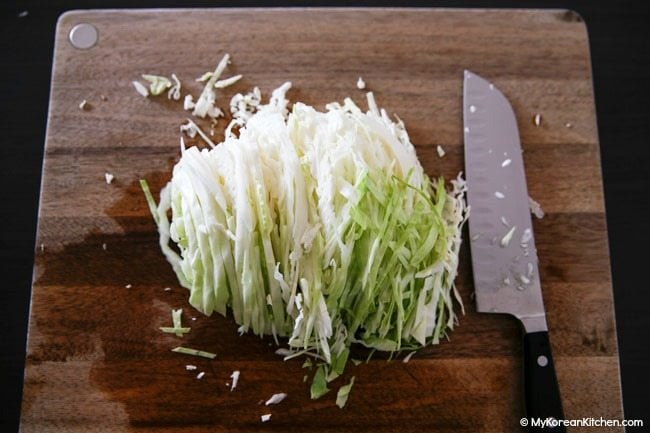 Thinly sliced cabbage on a cutting board