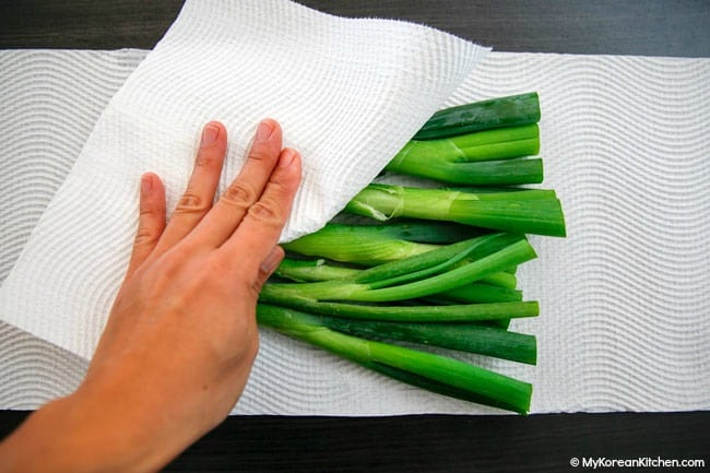 Wiping moisture on green onions with a kitchen paper