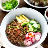 Ground beef and rice bowl topped with vegetables