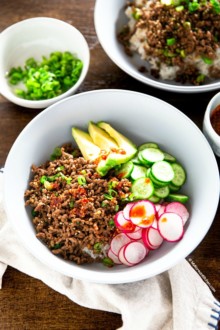 Ground beef and rice bowl topped with vegetables
