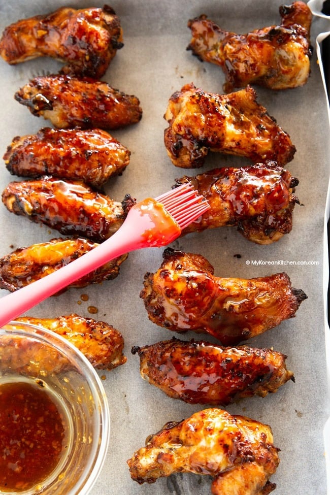 basting sauce over lined chicken wings