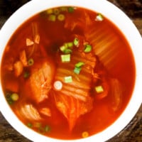 Kimchi soup served in a white soup bowl