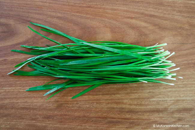 Garlic chives on wooden board