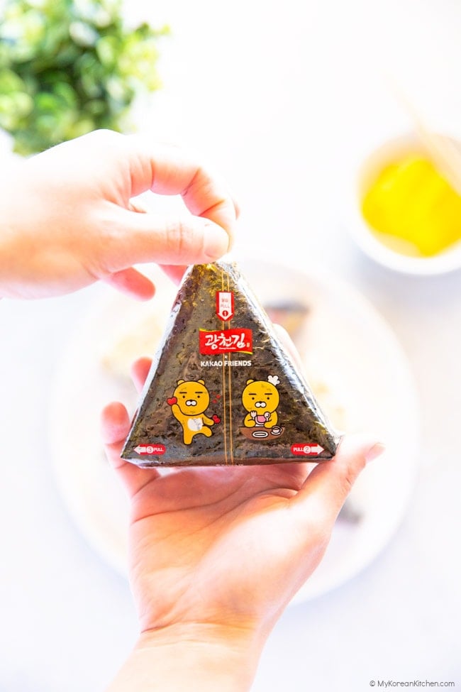 Holding the plastic tab of a triangle kimbap