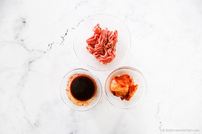 Pork mince, kimchi, and seasoning sauce on a whiteboard.