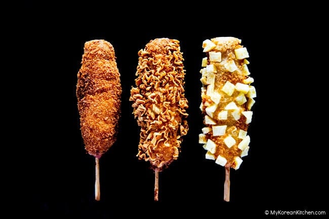 Each of the three corn dogs has a different coating—original (no coating), ramen noodles, and french fries.