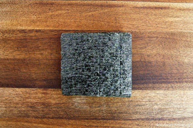 Dried seaweed is placed on a wooden board.