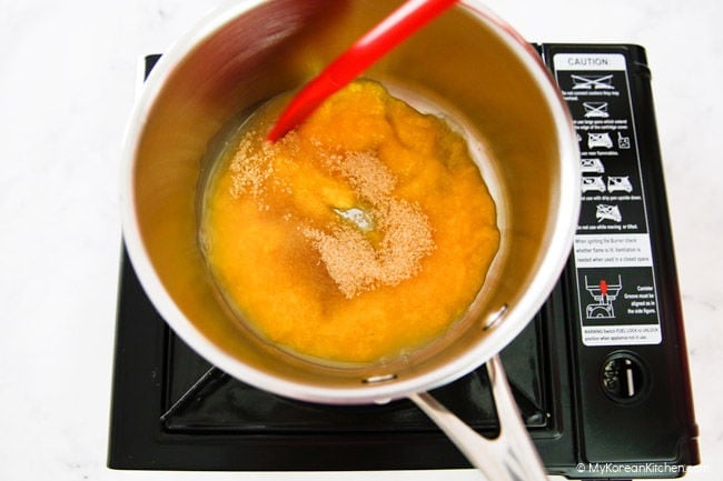 Combine mango puree and sugar in a pot over a stove.
