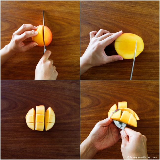 Cutting mangoes on a wooden cutting board.