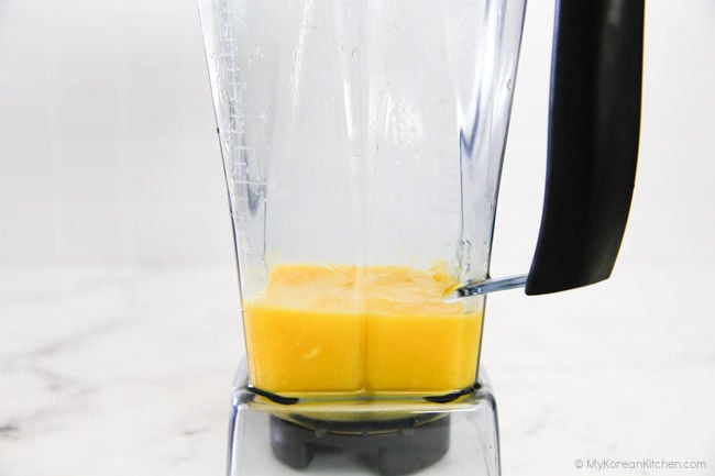Blending mango in a blender.