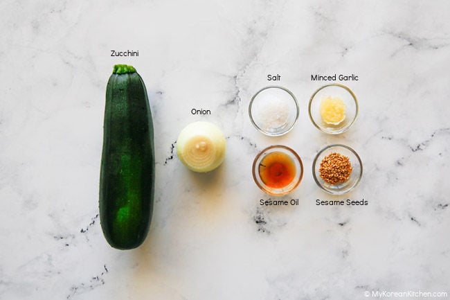 Ingredients for Korean zucchini stir fry laid out on a marble benchtop.