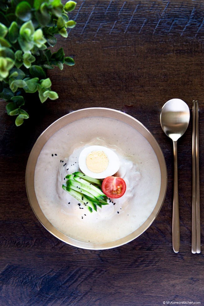 Kongguksu served in brassware on a wooden backdrop