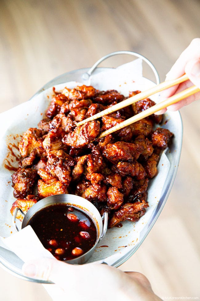 Holding Korean-style mala chicken with chopsticks.