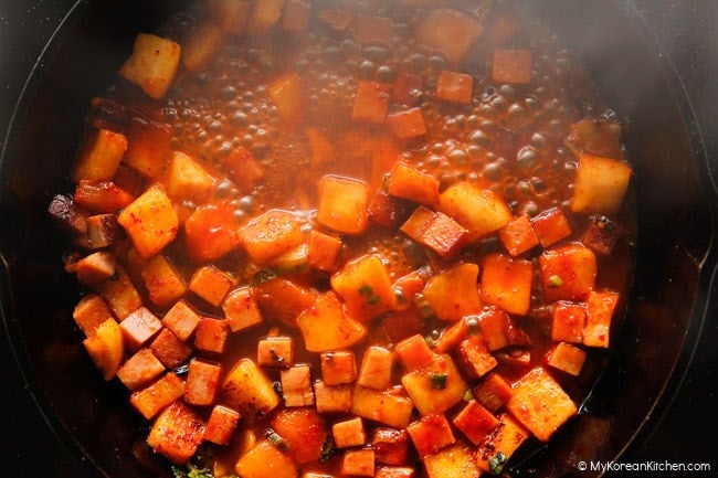 Simmering radish kimchi and spam in a savory fried rice sauce.