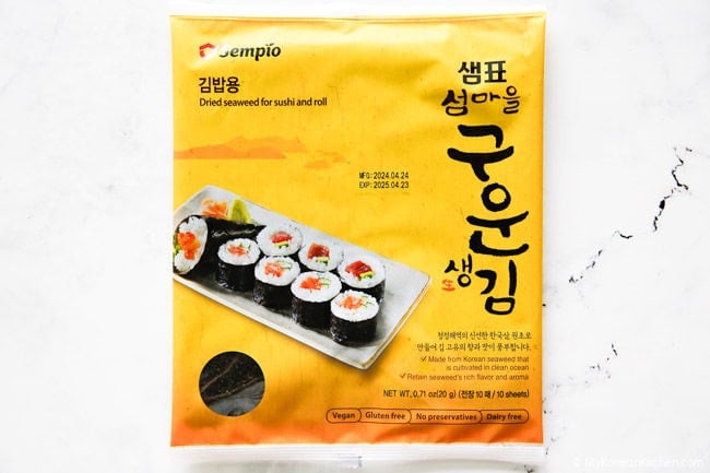 Kimbap seaweed placed on white countertop.