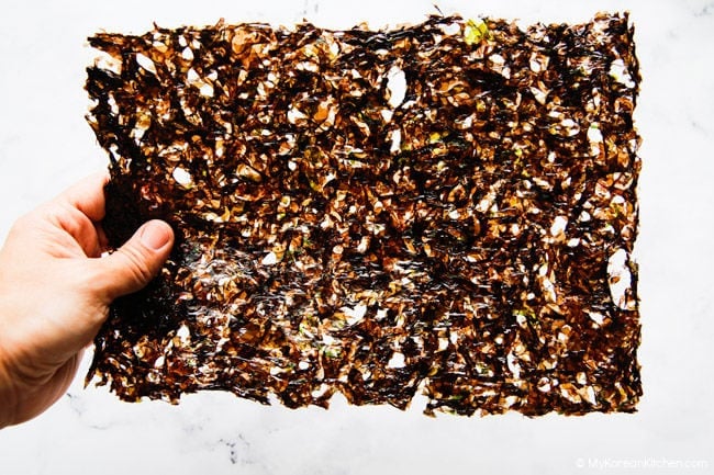 Holding gopchang seaweed against a white backdrop to show texture and appearance.