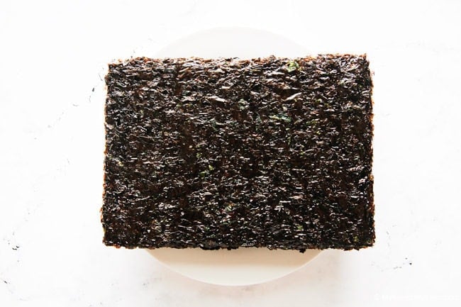 Dried seaweed piled on a white plate before roasting.