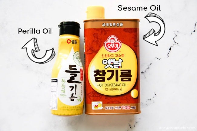 Perilla oil and sesame oil placed on a white countertop.