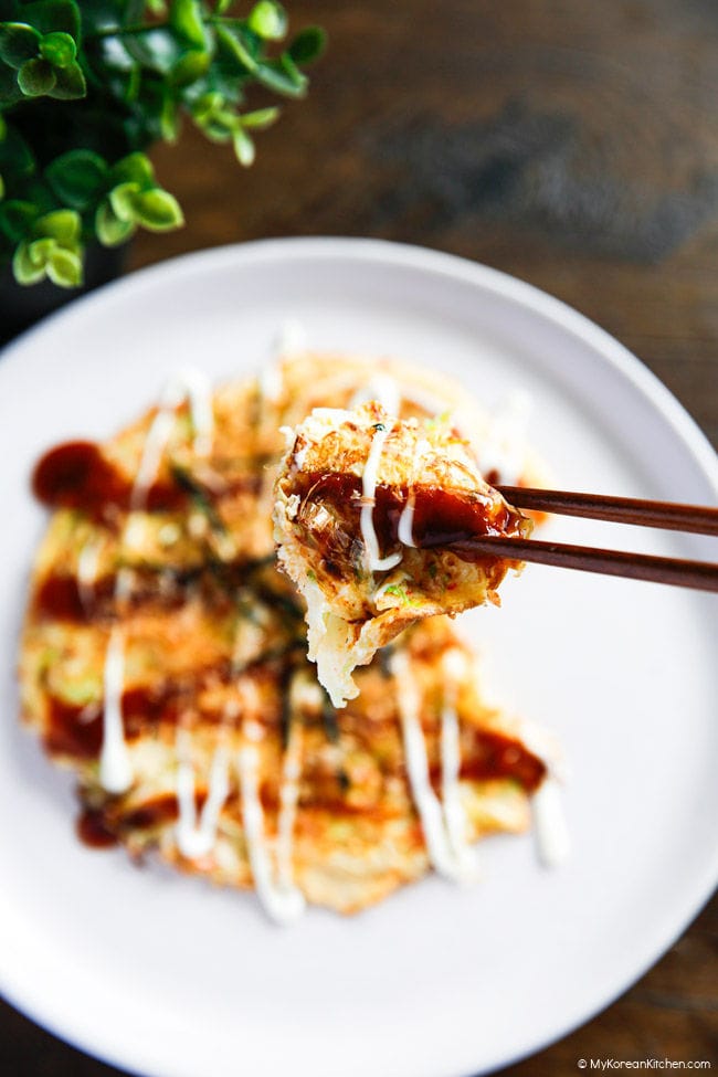 Holding a small piece of cabbage egg omelette with chopsticks.