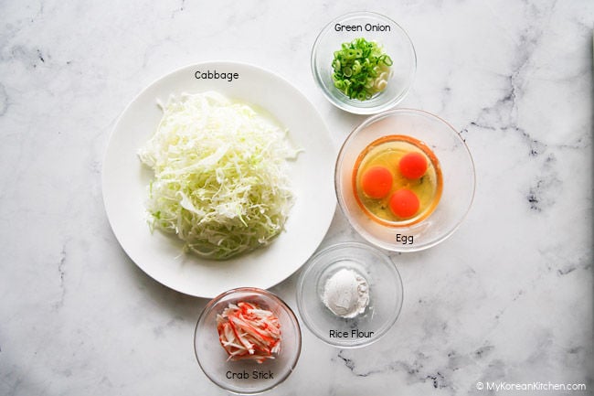 Ingredients for cabbage egg omelette on a white countertop.