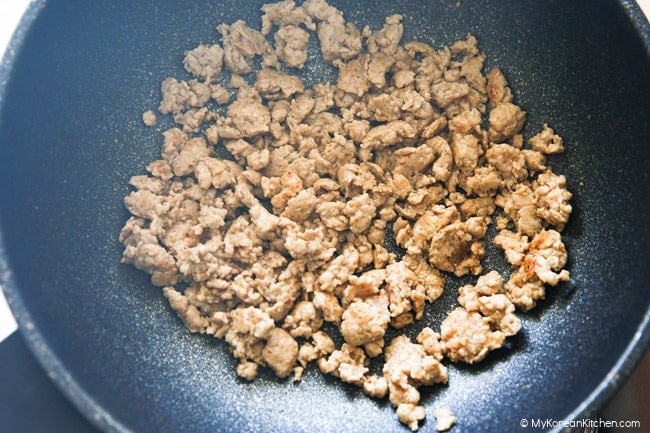 Stir frying marinated pork in a skillet