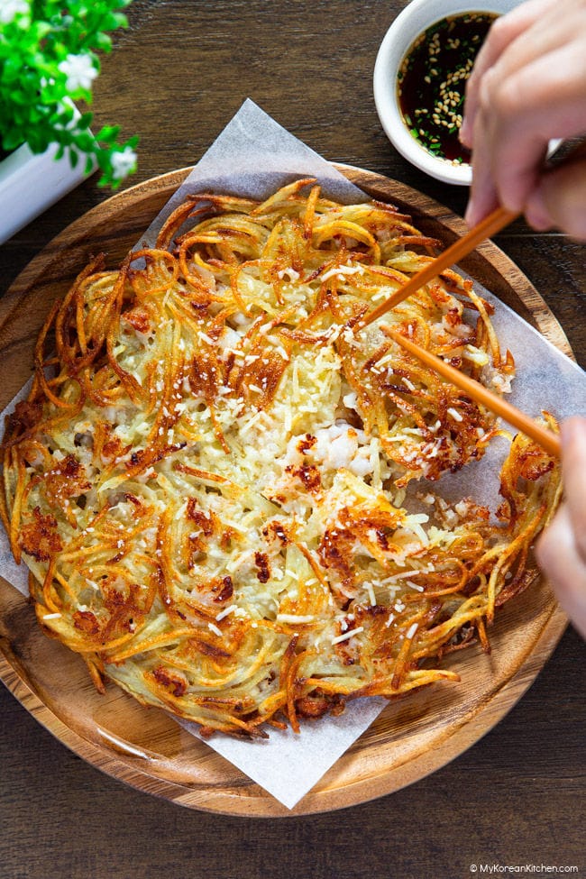 Pulling apart the pancake with chopsticks.