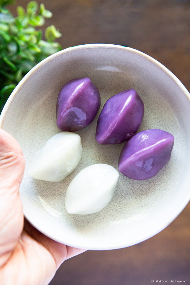 Holding a white plate with purple and white songpyeon