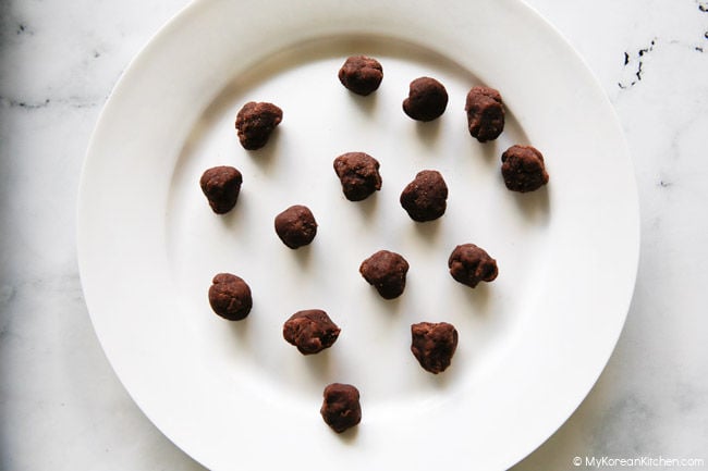 Sweet red bean paste balls rolled and placed on a large white plate