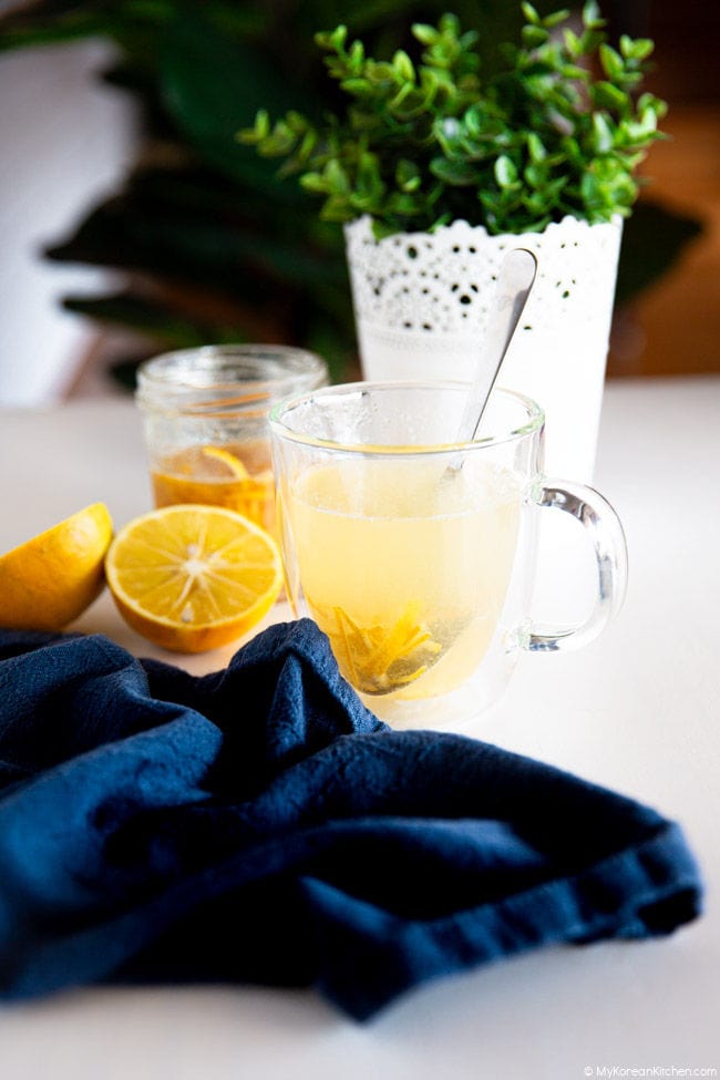Lemon tea on a white board with a navy napkin wrapped around the teacup.