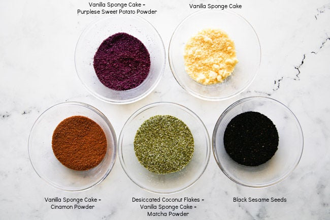 Five bowls of gyeongdan coating options arranged on a white marble style countertop.