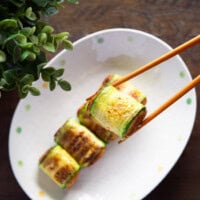 Korean zucchini rolls hobak mari held with chopsticks