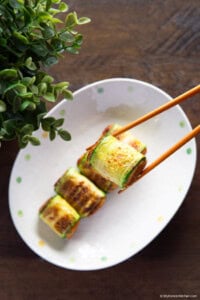 Korean zucchini rolls hobak mari held with chopsticks