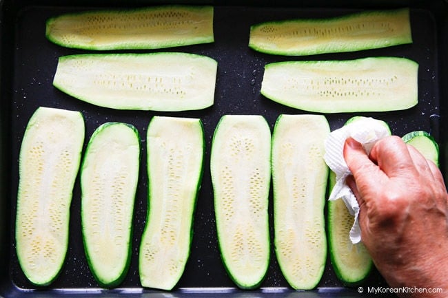 wiping moisture from salted zucchini slices