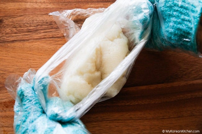Putting steamed injeolmi dough into a plastic bag to rest and knead