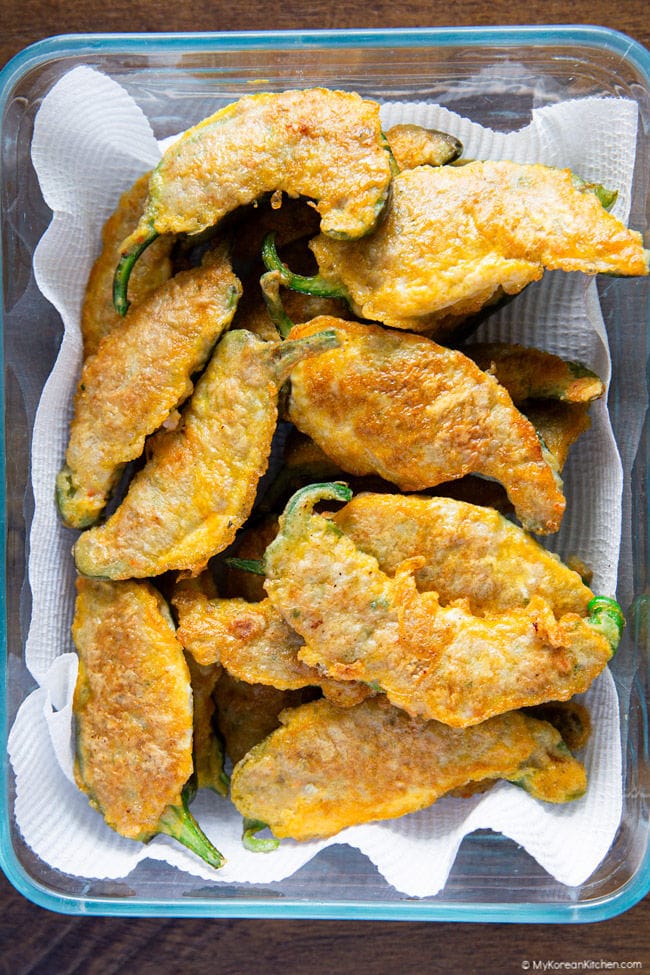 Korean stuffed chili peppers arranged in a rectangular container lined with paper towel.