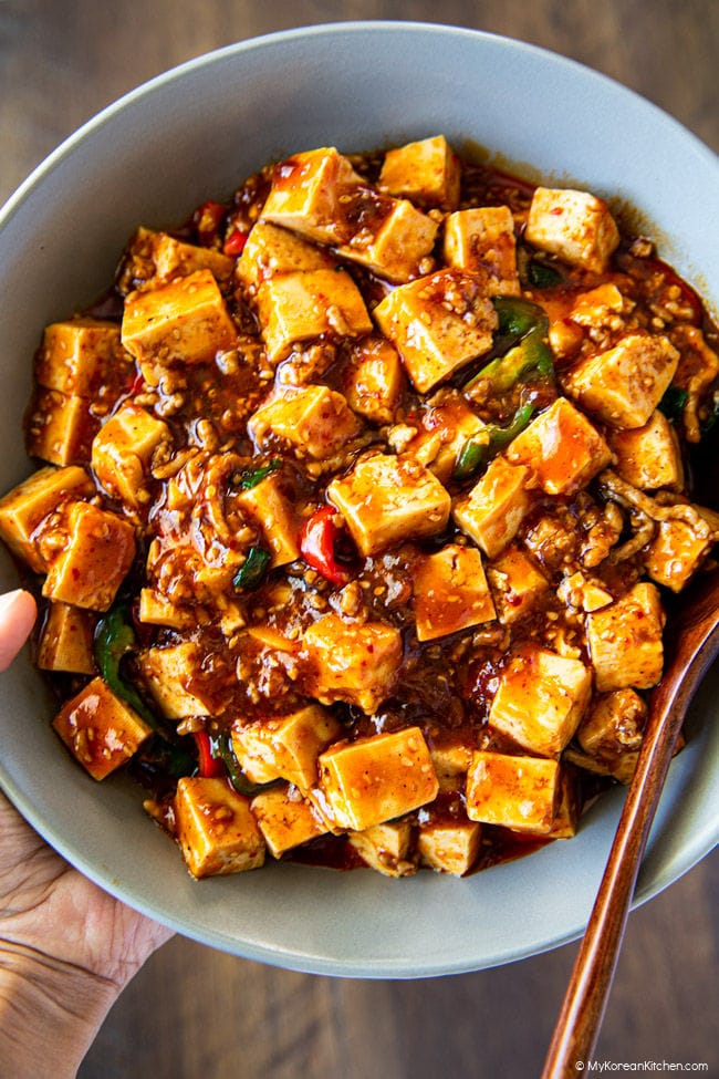 Close-up photo of a bowl of Korean mapo tofu held in a hand