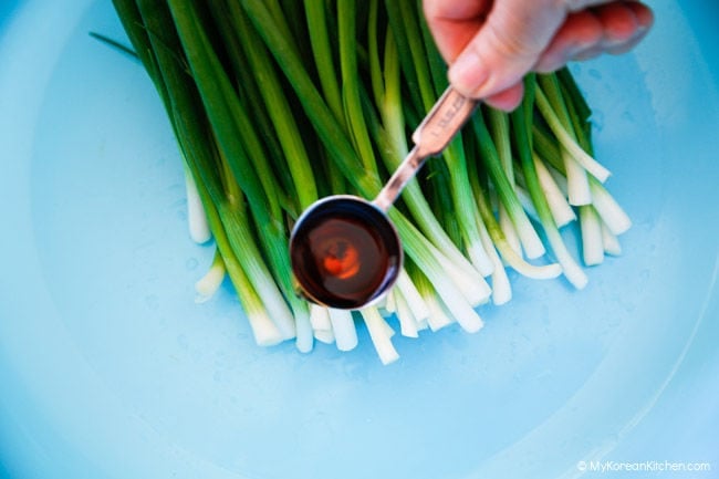pre-seasoning the white parts of green onions with fish sauce for pa kimchi
