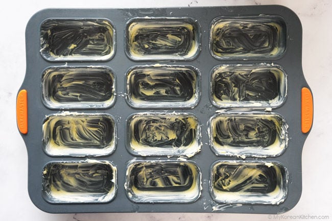 greasing the baking pan with butter for butter tteok