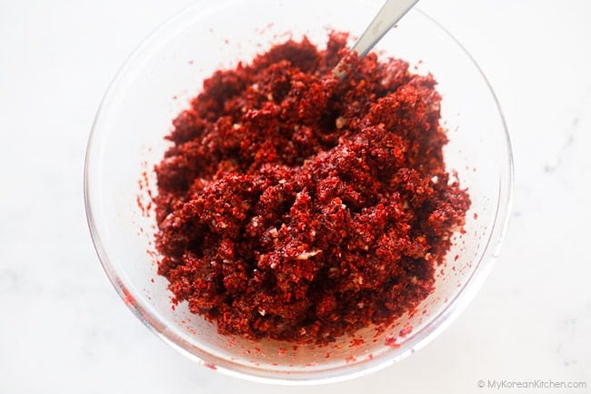 gochugaru softening in a glass mixing bowl.