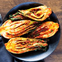 Homemade bok choy kimchi served in a black bowl