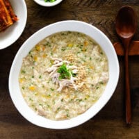 Homemade dakjuk served warm in a bowl with chicken and green onion garnishes